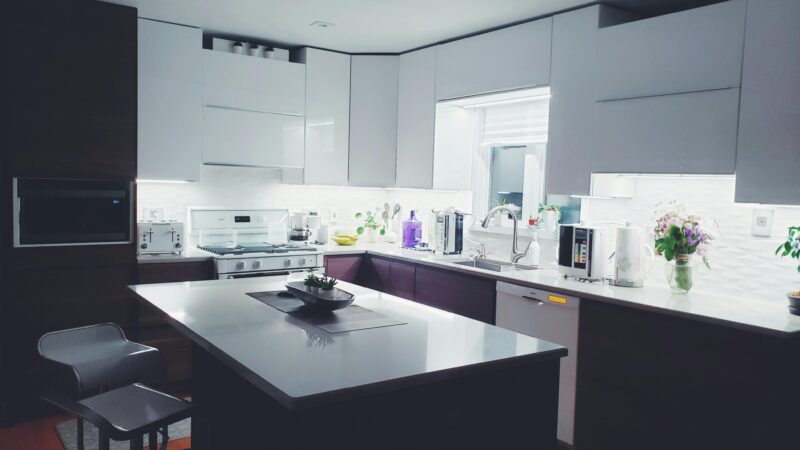 Contemporary kitchen interior with sleek white cabinets and island, perfect for a minimalist aesthetic.