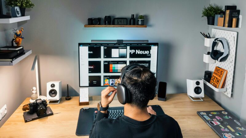 Cozy and organized home office workspace featuring a desktop computer, headphones, and creative decor.